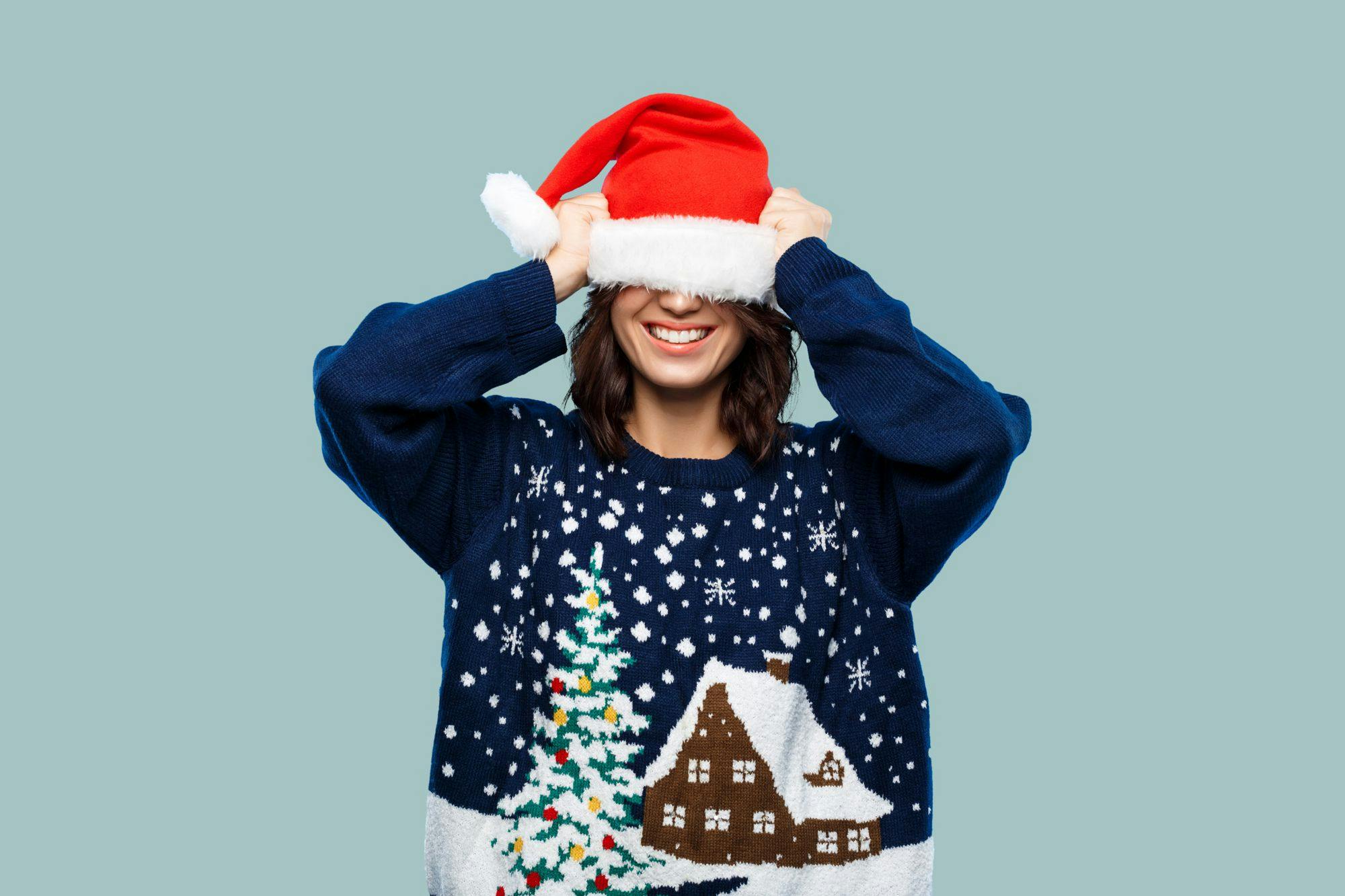Woman covering her face with santa hat